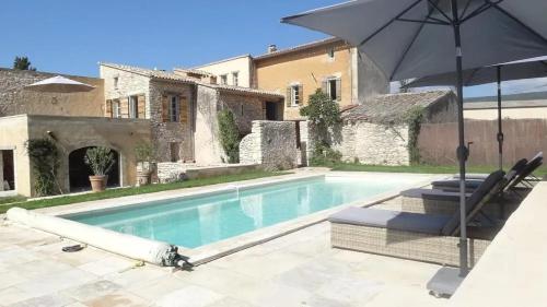 - une piscine avec un parasol et des chaises à côté d'une maison dans l'établissement Villa spacieuse à Saint-Saturnin-lès-Apt avec piscine privée 350 m², à Saint-Saturnin-lès-Apt