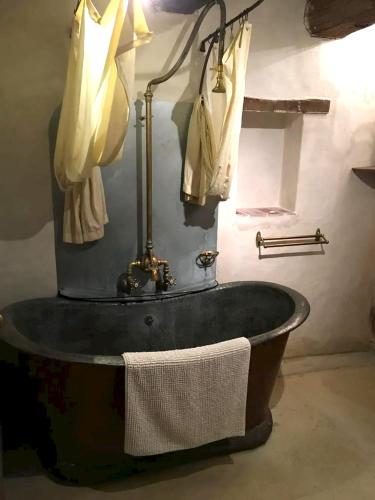 une baignoire noire dans une salle de bain avec des serviettes dans l'établissement Villa spacieuse à Saint-Saturnin-lès-Apt avec piscine privée 350 m², à Saint-Saturnin-lès-Apt