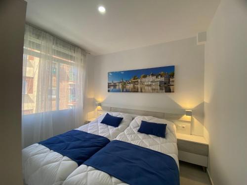 1 dormitorio con 1 cama grande con almohadas azules en La Pilarica, en Madrid