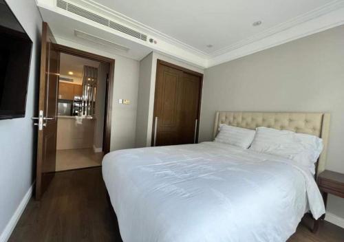 a bedroom with a large white bed and a bathroom at Apartment with Ocean view in Danang