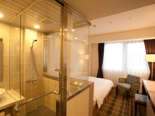 a hotel room with a shower and a bathroom at Chisun Grand Takayama in Takayama