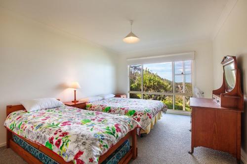 a bedroom with two beds and a window at Spectacular Views in Mollymook