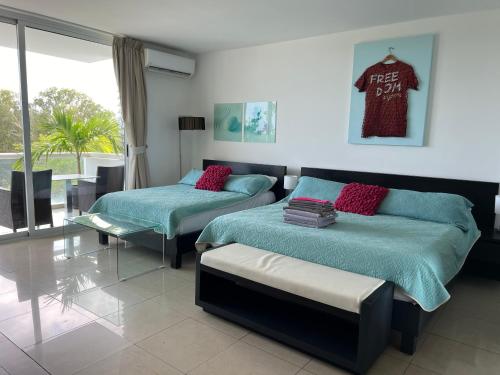 Un dormitorio con 2 camas y un banco. en Town Center Paradise in Playa Blanca en Playa Blanca