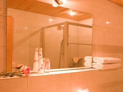 uma casa de banho com um espelho e um lavatório com toalhas em Tranquil holiday home with large garden em Balderschwang