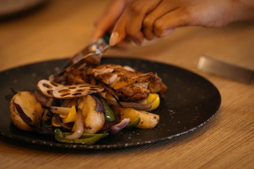 a person cutting a plate of food on a table at THE SENAGAJIMA STORYLINE in Tomigusuku