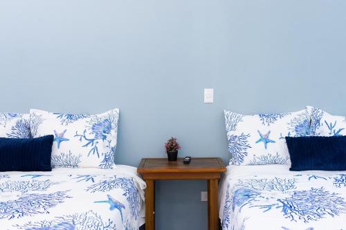 - 2 lits avec des oreillers bleus et blancs et une table dans l'établissement Estancia Florencia H#4, à Tela