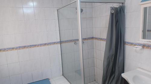 a shower with a glass door in a bathroom at De'moore Guest House in Johannesburg