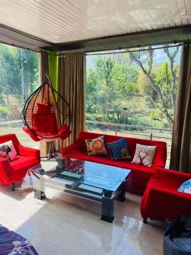 sala de estar con sofá rojo y mesa de cristal en Peaceful stacation in Bilaspur, en Bhakra Dam