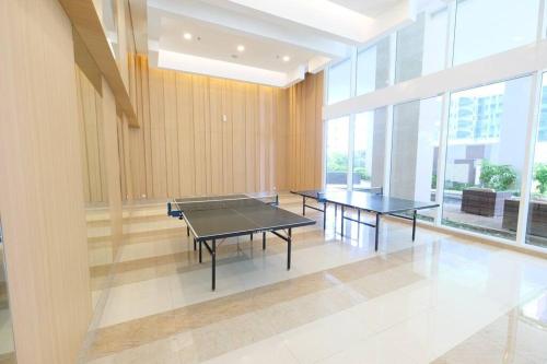 duas mesas de pingue-pongue numa sala com janelas em PodomoroLiberty 54m 2BR, 2Bed, 1 Sofabed 4-6person em Medan
