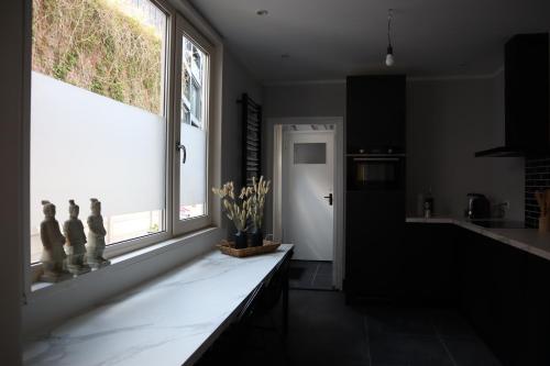 uma cozinha com um balcão e uma grande janela em De Stadsoase Tilburg em Tilburg