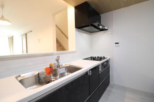 a kitchen with a sink and a stove at King's House in Osaka