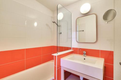 La salle de bains est pourvue d'un lavabo blanc et d'un miroir. dans l'établissement Résidence Quartier Falaise - maeva Home - Appartement 2 pièces 7 personnes 844, à Avoriaz
