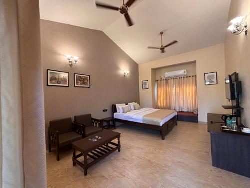 a bedroom with a bed and a couch and a tv at Aranyak Resort in Tāla