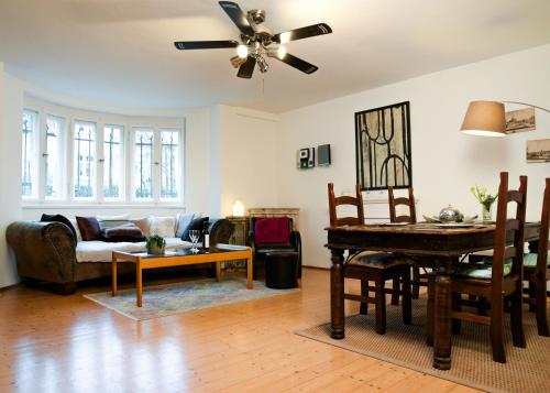 a living room with a ceiling fan and a table at Ferienwohnung Weintraube in Dresden