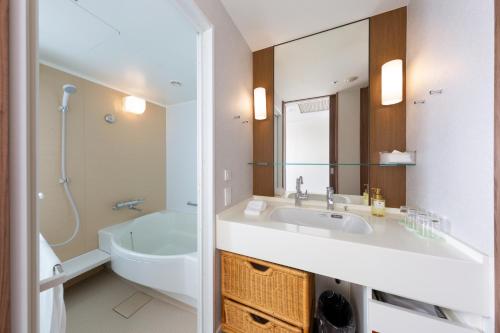 uma casa de banho com um lavatório, um WC e um espelho. em Tokyo Bay Maihama Hotel em Urayasu