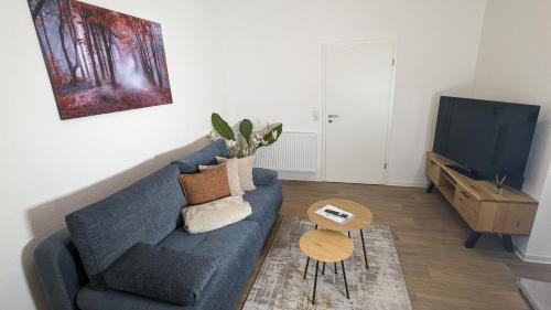 a living room with a blue couch and a tv at Ferienwohnung Urban -Ekhof- in Gotha