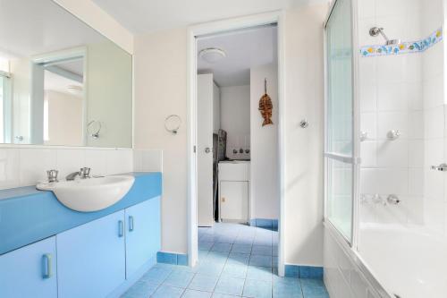 a white bathroom with a sink and a shower at Jade Waters U4 5 Latona Ave in Caloundra