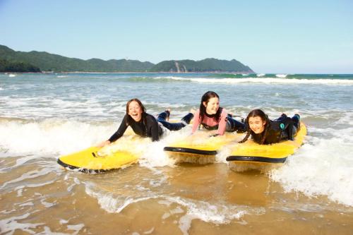 a group of people ridingogie boards in the water at PACIFICO SURF HOUSE - by the Sea in Shishikui