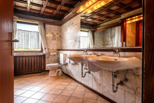 ein Badezimmer mit zwei Waschbecken und einem WC in der Unterkunft Hotel Spahr in Stuttgart