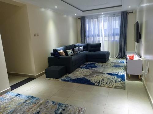 a living room with a blue couch and a television at Atalia Athi River in Nairobi