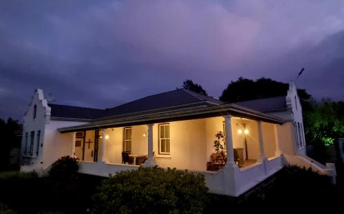 Una casa blanca con luces por la noche. en The Elizabeth Riviersonderend, en Riviersonderend