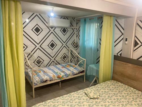 ein kleines Schlafzimmer mit einem Bett und einer Wand in der Unterkunft Studio Bandrélé in Bandrélé