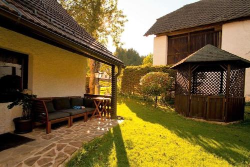 un sofá sentado fuera de una casa con cenador en Green Inn Homestead With Sauna, en Dravograd