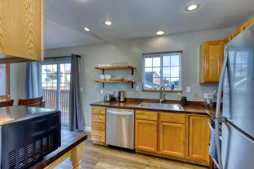 a kitchen with wooden cabinets and a stainless steel refrigerator at Rustic Retreat Charming 2 Bedroom Apt Sleeps 4 in Kodiak