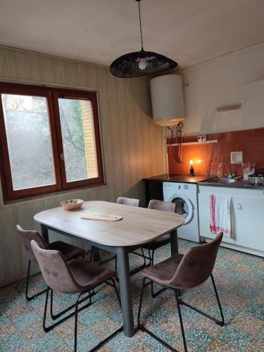 a kitchen with a table and chairs in a room at Saint-Michel de Maurienne, appartement de 45 m² in Saint-Michel-de-Maurienne