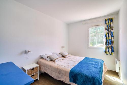 une chambre blanche avec un lit et une fenêtre dans l'établissement Les Maisons de Lacanau les Pins - maeva Home - Maison 3 pièces 6 personnes - Sélection MAE-2031, à Lacanau