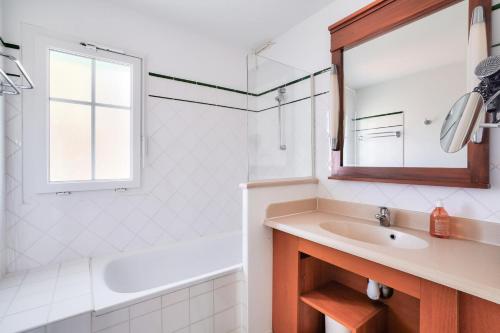 une salle de bain blanche avec un lavabo et un miroir dans l'établissement Les Maisons de Lacanau les Pins - maeva Home - Maison 3 pièces 8 personnes - Prestige MAE-2061, à Lacanau
