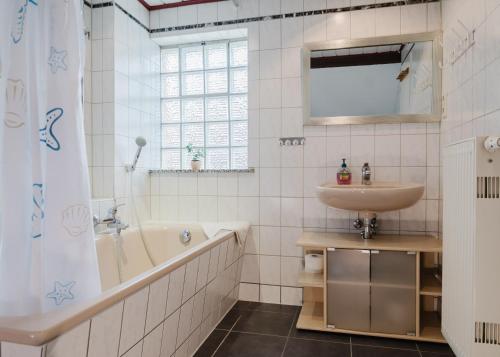 a bathroom with a tub and a sink and a bath tubermottermott at Trobischhof in Dresden