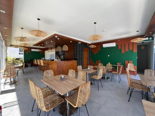 ein Restaurant mit Tischen und Stühlen und einer grünen Wand in der Unterkunft Porto Novo Anilao Dive and Leisure Resort in Mabini