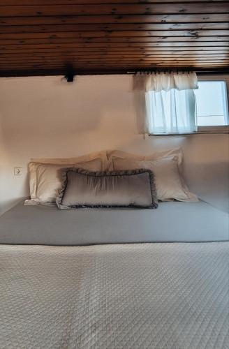a bed in a room with a window at Secret Garden Petite Home Lagonissi Attiki in Kalívia Thorikoú