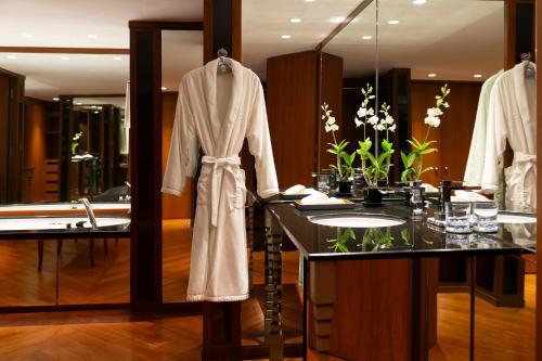 a bathroom with a robe hanging on a rack at The Sukhothai Bangkok in Bangkok