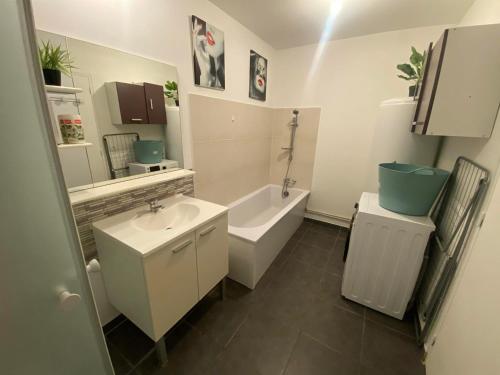 een badkamer met een wastafel, een bad en een toilet bij Maison avec jardin. in Troarn