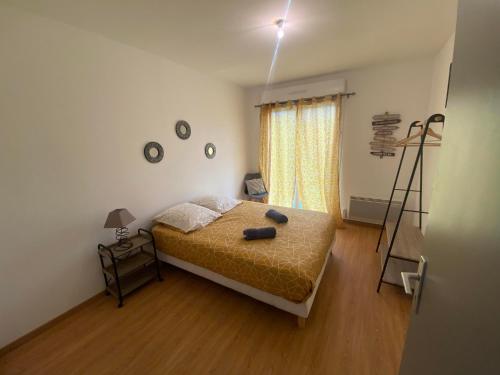 een slaapkamer met een bed en een lamp erin bij Maison avec jardin. in Troarn