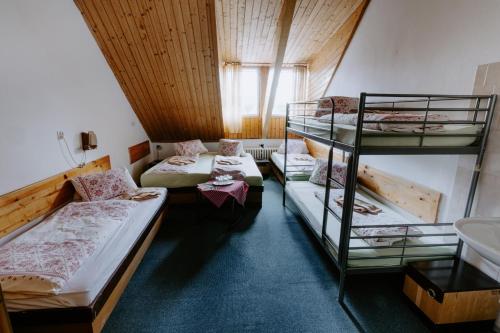 Turistické ubytovanie Sova في زديار: غرفة بها ثلاثة أسرة بطابقين ومغسلة