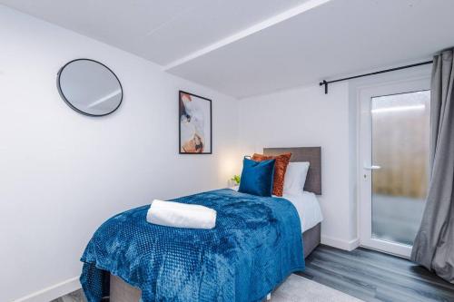 ein Schlafzimmer mit einem Bett mit einer blauen Decke in der Unterkunft Beautiful Pontefract House w/ Parking Sleeps 12 by PureStay in Pontefract