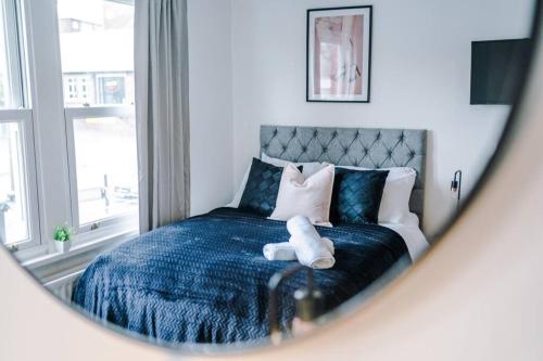 um quarto com uma cama azul com um ursinho de peluche em Beautiful Pontefract House w/ Parking Sleeps 12 by PureStay em Pontefract