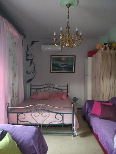 a bedroom with a bed and a chandelier at Kalys House in Kavála