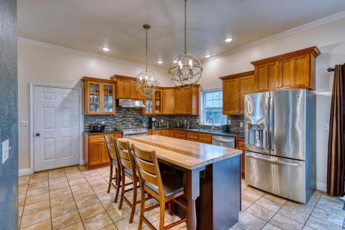 a kitchen with a wooden table and a stainless steel refrigerator at Rustic Elegance 7 Bedrms 4 bath Cathedral Ceilings in Kodiak