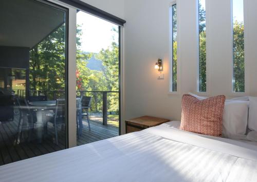 a bedroom with a bed and a large window at Hygge in Harrietville