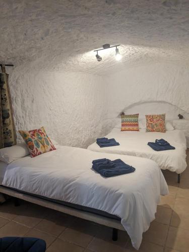 two beds in a room with towels on them at Cuevas Barrio Las Santas in Huéscar