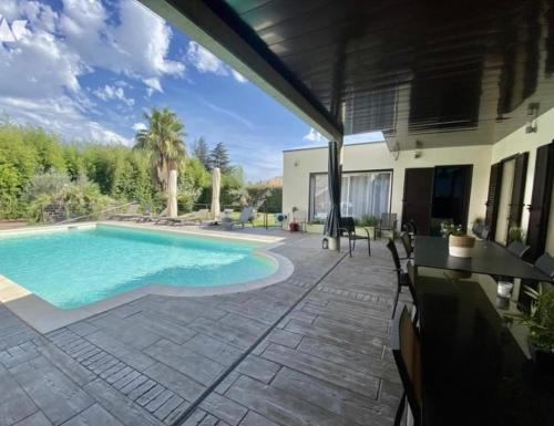 un patio con piscina e una casa di HISTOIRE D'Ô - Les Piscines - Chambres d'hôtes a Bezouce