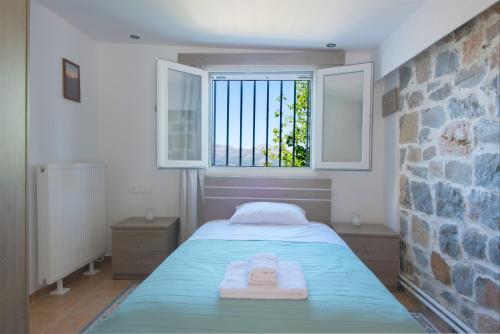 a bedroom with a bed with a towel on it at Skapani's House in Mésa Lasithákion