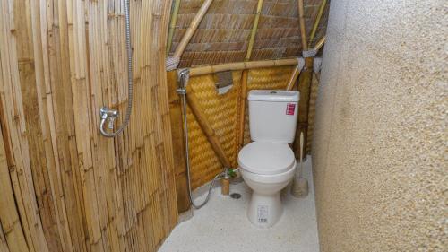 a bathroom with a toilet in a wooden wall at Samui Circus Studio & Ville - Dome Bungalow 5 in Amphoe Koh Samui