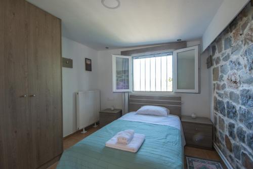 a bedroom with a bed with two towels on it at Skapani's House in Mésa Lasithákion