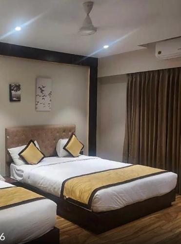 a bedroom with two beds and a window at SVR Sai Paradise Hotel in Shirdi