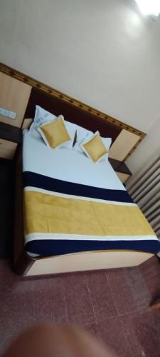 Un dormitorio con una cama con almohadas. en SVR Sai Paradise Hotel, en Shirdi